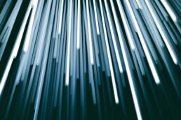 Streaks of white and blue light rising diagonally against a dark background