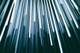 Streaks of white and blue light rising diagonally against a dark background