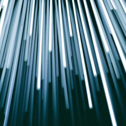 Streaks of white and blue light rising diagonally against a dark background