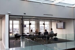 Business team meeting in a modern glass conference room with a city view